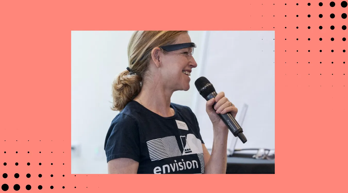 vanessa wearing the envision glasses with a mic in her hand conducting a demo